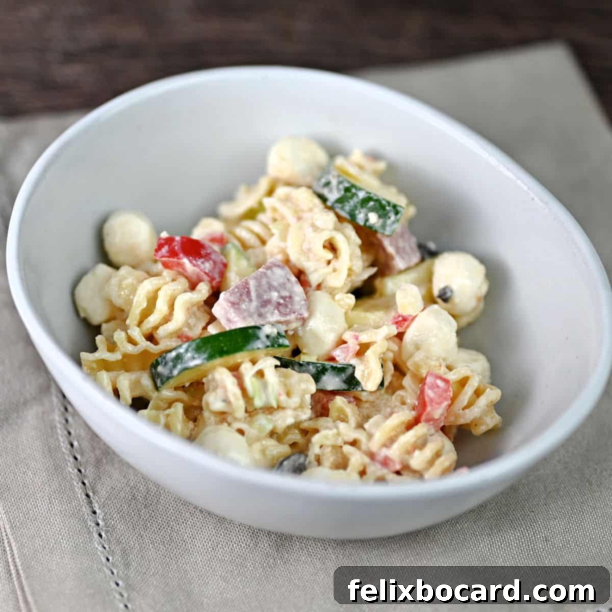 small bowl of pasta salad with salami and veggies.