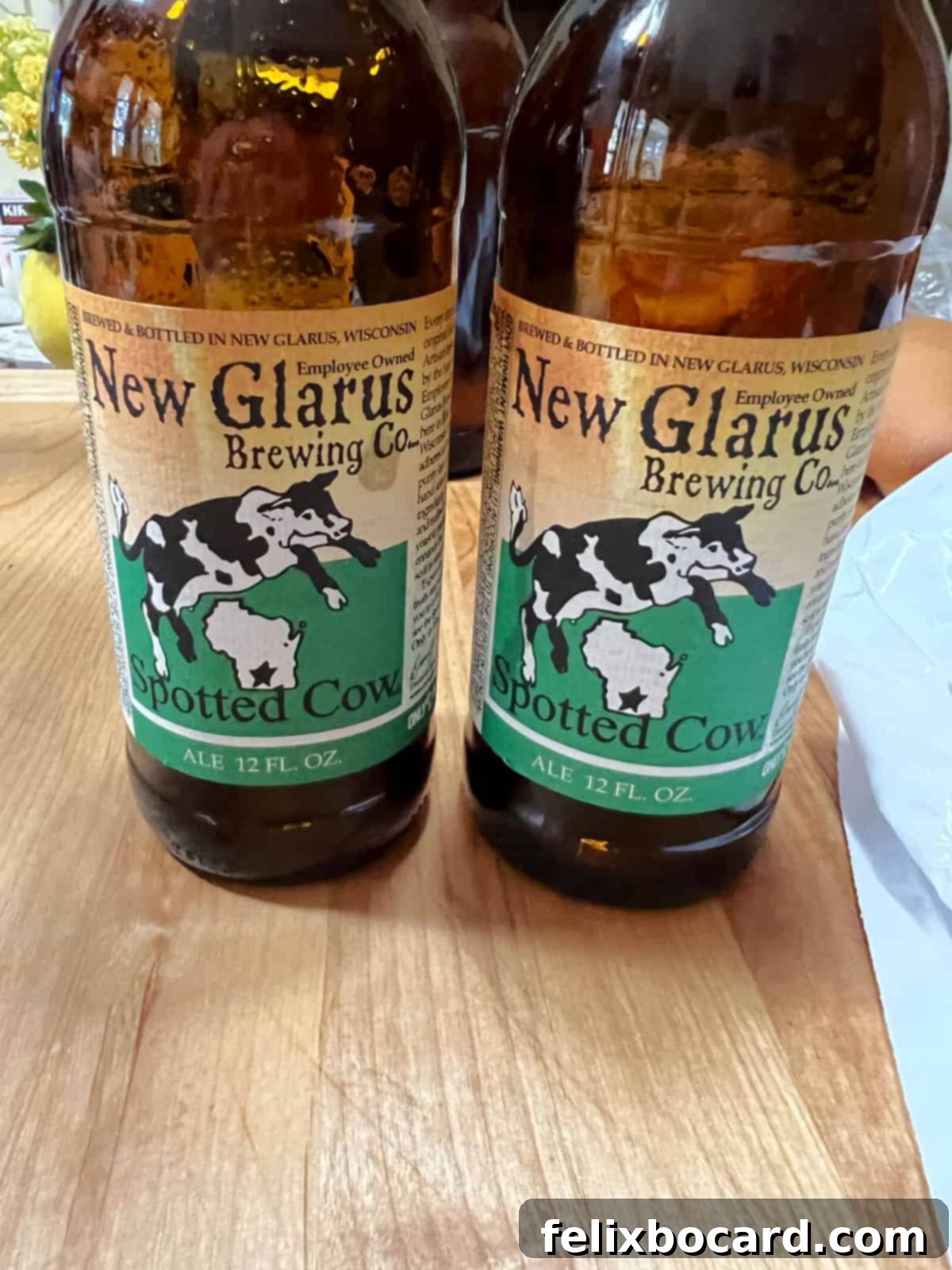 Classic Wisconsin Beer Brats 10 Two bottles of New Glarus Spotted Cow beer, a popular Wisconsin brew, poised for a delicious brat bath.