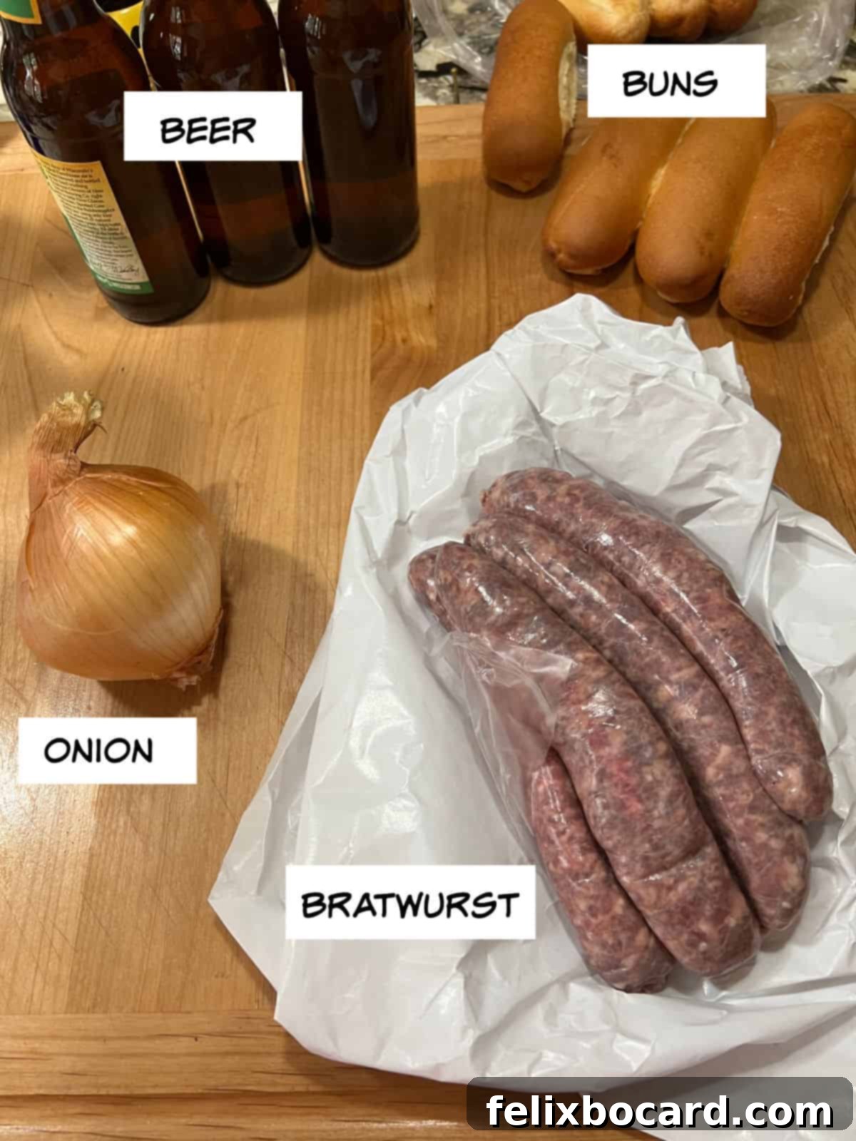 Classic Wisconsin Beer Brats 3 Fresh ingredients laid out: beer bottles, sliced yellow onion, raw bratwurst, and soft brat buns.