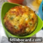 Air fryer egg bite in a green silicone cup.