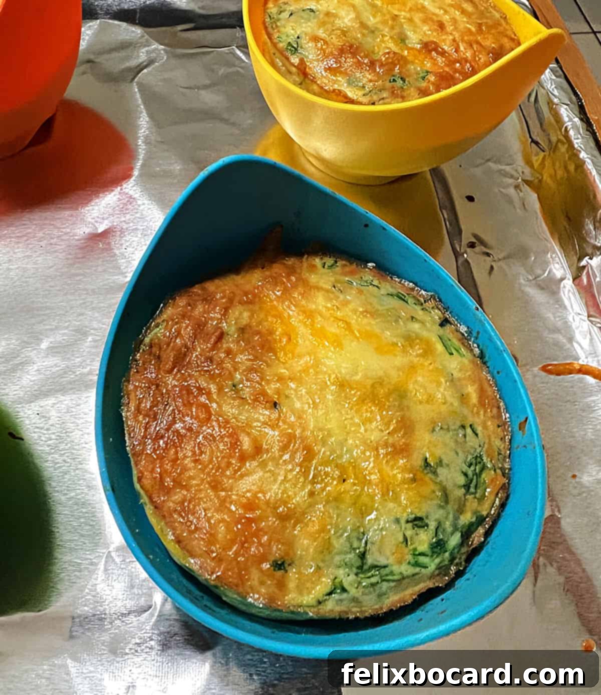 A single browned egg bite nestled in a blue silicone mold, ready to be enjoyed or stored.