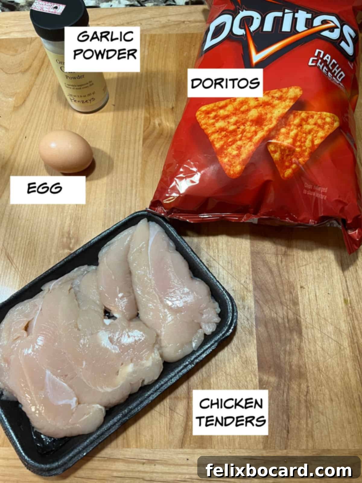 Crunchy Doritos Air Fryer Chicken Tenders 3 Key ingredients laid out: garlic powder, a bag of Doritos, raw chicken tenders, and an egg.