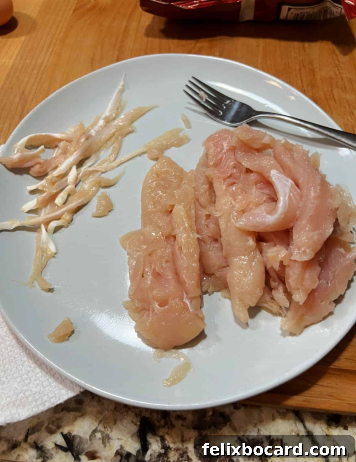 Crunchy Doritos Air Fryer Chicken Tenders 6 Plate of raw chicken tenderloins, with removed tendons neatly placed to the side.