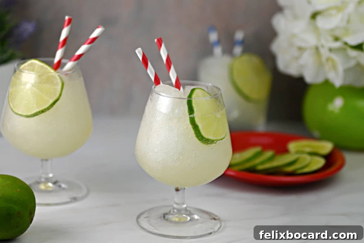 Blended Daiquiri Bliss 2 Frozen daiquiri slush served in a stemmed cocktail glass and striped straws.