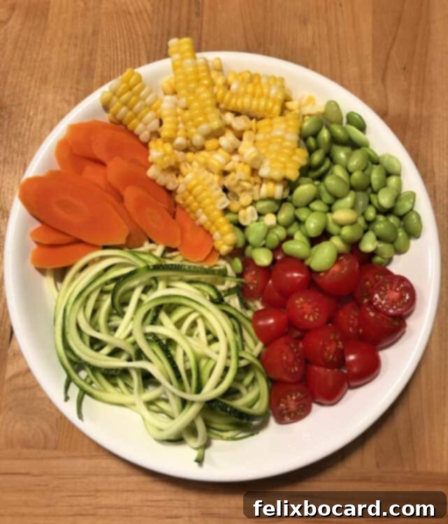 Close-up of a colorful Confetti Corn Zoodle Bowl filled with fresh vegetables and creamy dressing