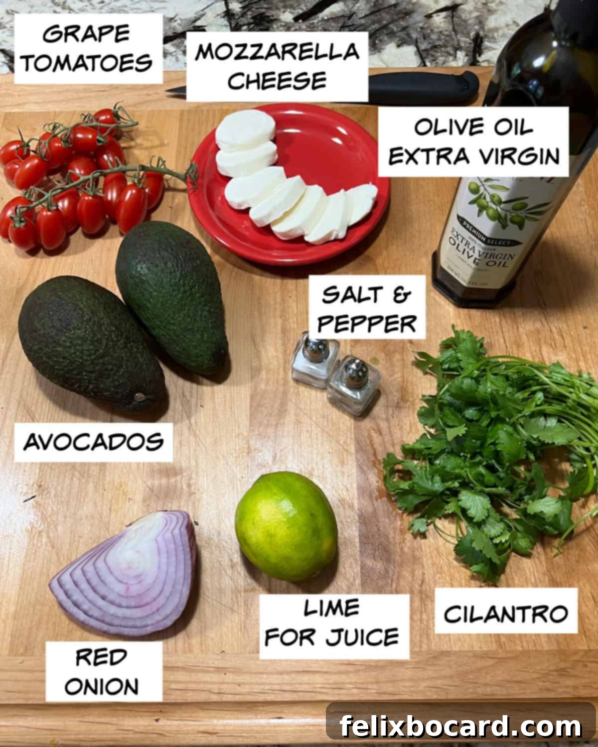 A collection of fresh ingredients laid out for Mexican Avocado Salad: grape tomatoes, ripe avocados, red onion, lime, fresh cilantro, salt, pepper, olive oil, and mozzarella cheese.