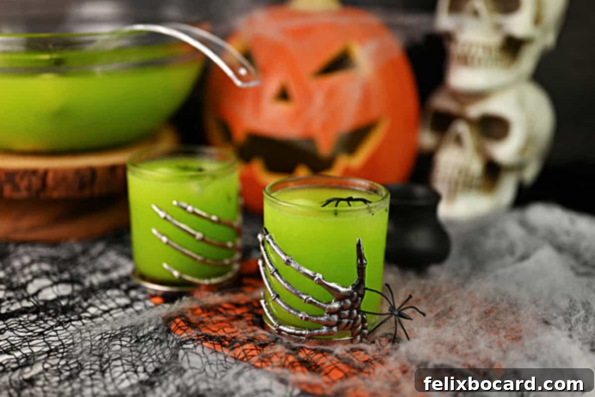 Monster Mash Punch 2 Witches brew cocktail in 2 skeleton hand glasses with a punch bowl filled with more behind.