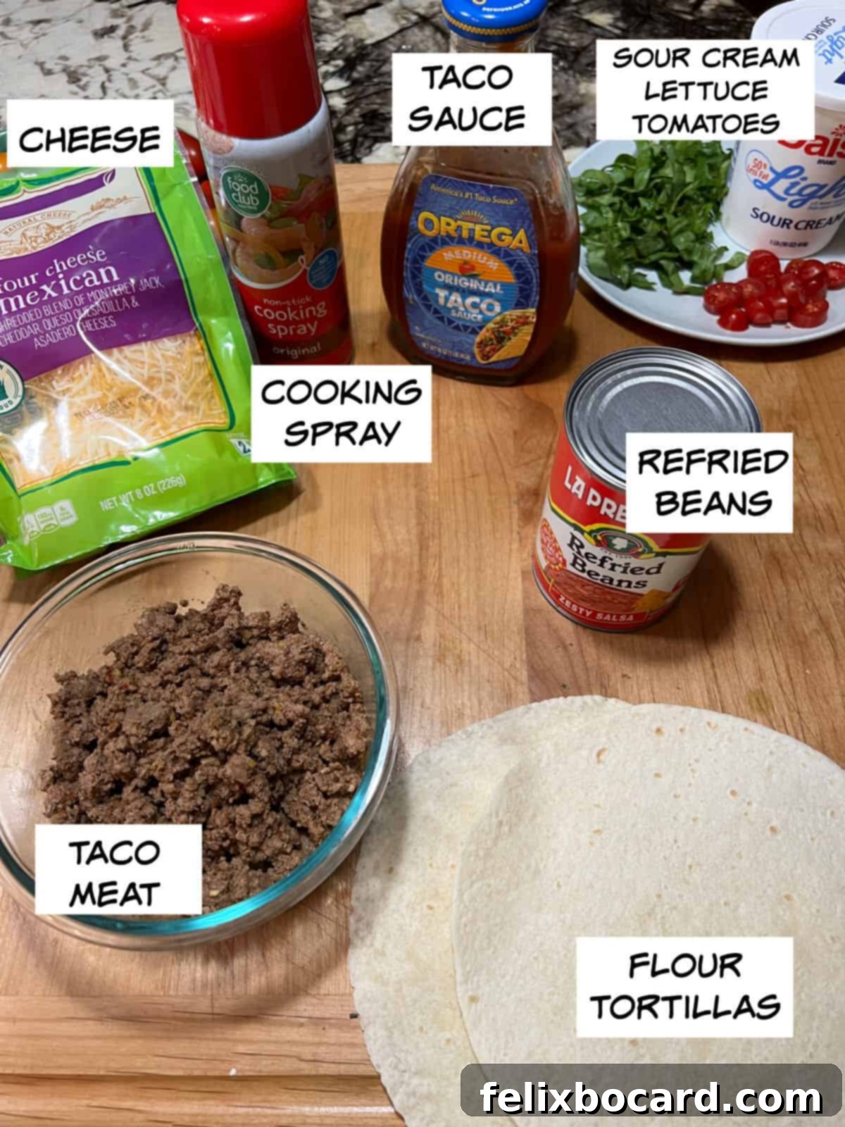 Ingredients: cheese, cooking spray, taco sauce, sour cream, lettuce, and tomatoes, refried beans, flour tortillas, and taco meat.