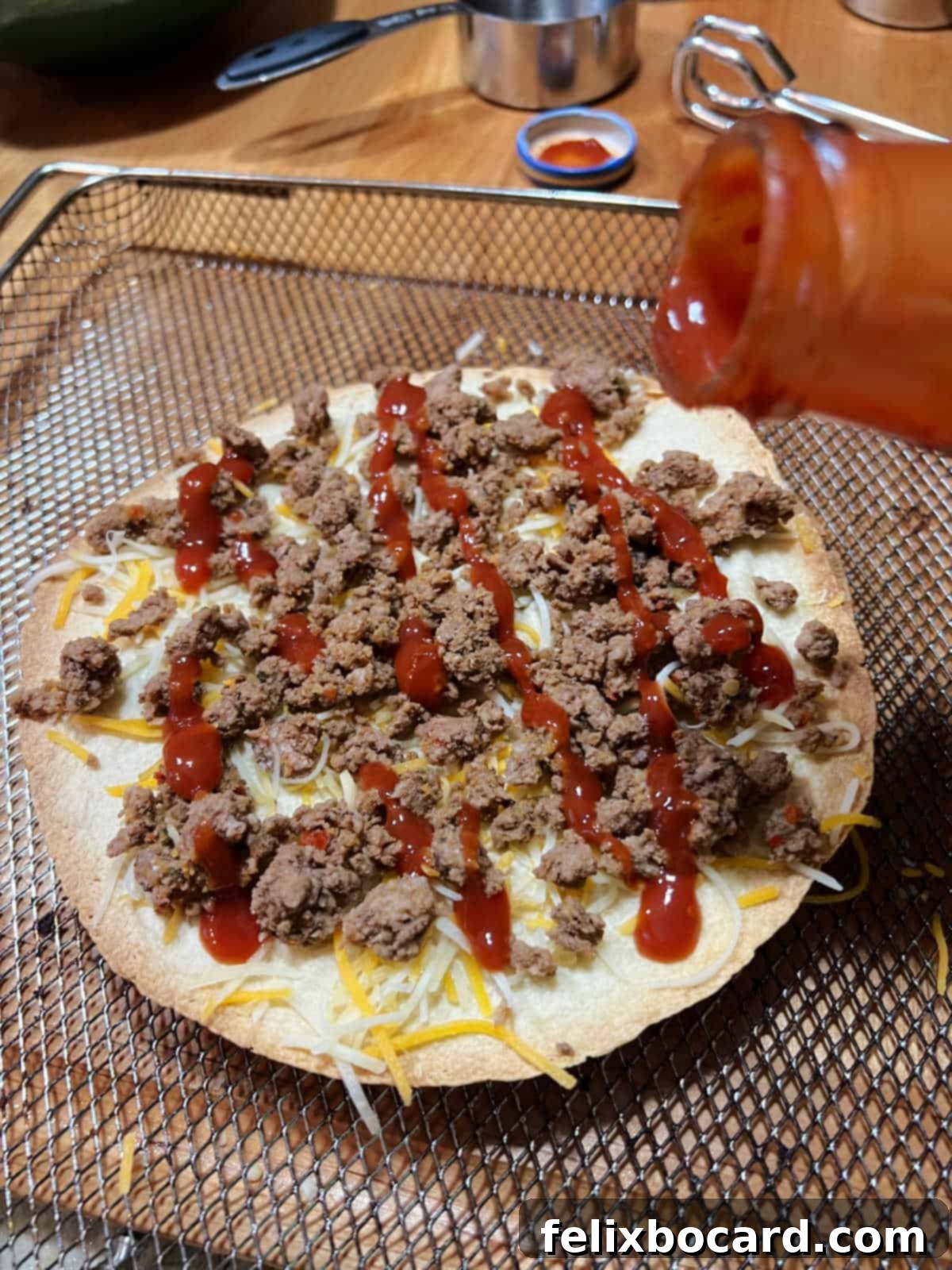 Drizzling taco sauce on the pizza.
