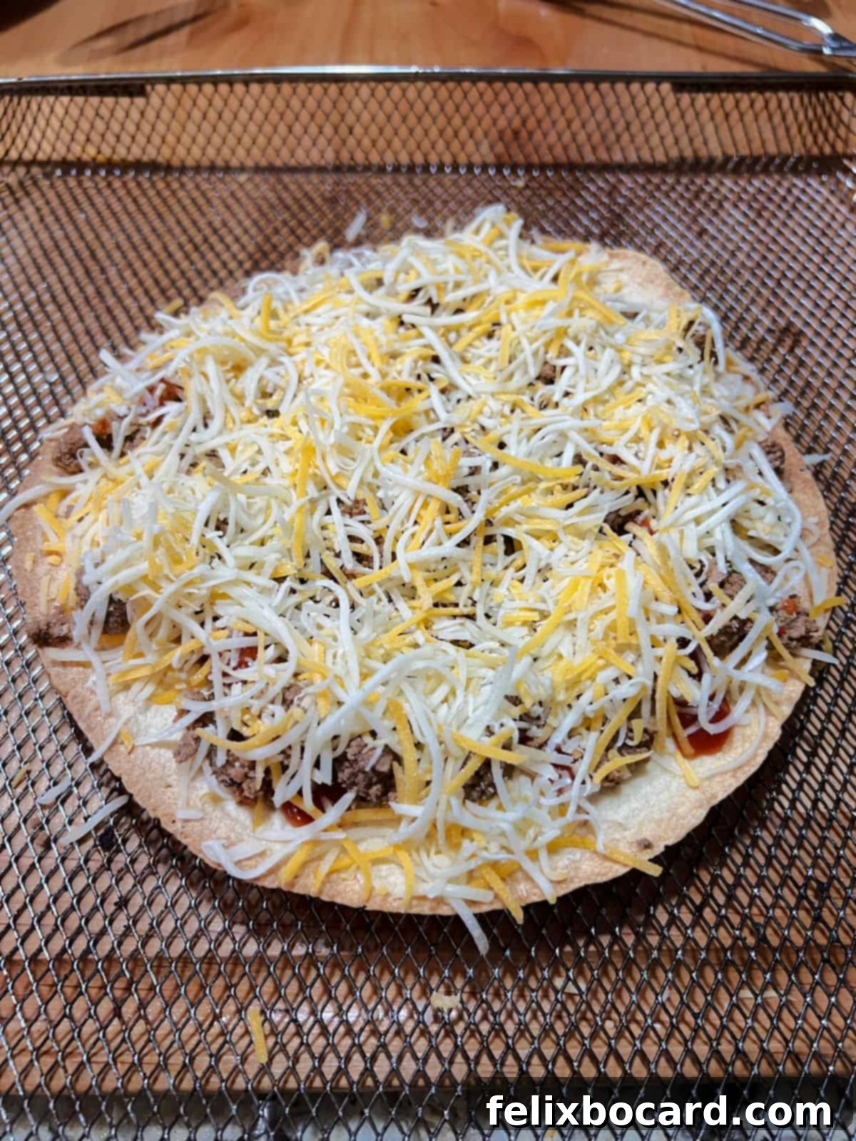 Cheese covering the uncooked pizza.