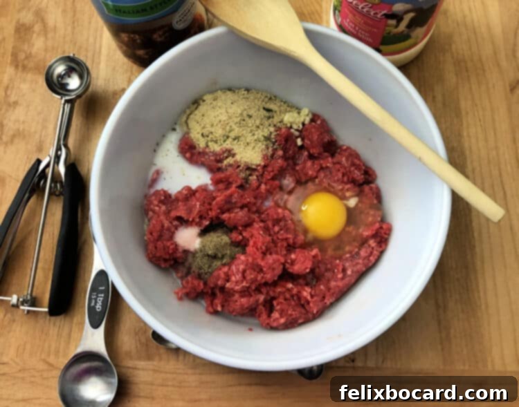 Make Ahead Freezer Meatballs 3 A vibrant selection of fresh ingredients laid out, including ground beef, ground pork, eggs, milk, breadcrumbs, minced garlic, dried minced onion, Italian seasoning, salt, and pepper, ready to be combined for homemade freezer meatballs.