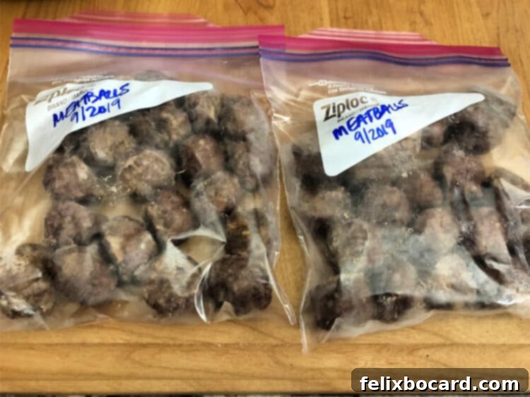 Make Ahead Freezer Meatballs 7 Several clear zip-top bags filled with individually frozen meatballs, neatly stacked and ready for long-term freezer storage, demonstrating efficient meal prep and organization.