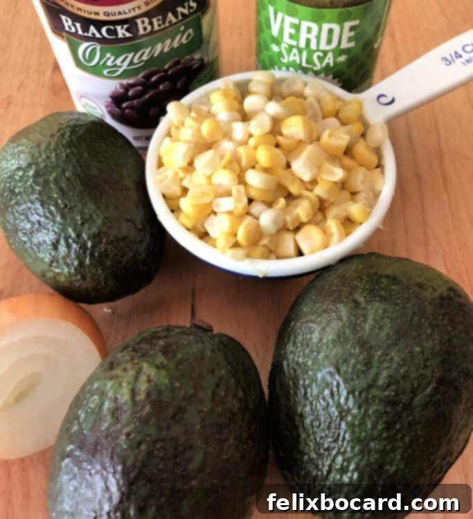 Black Bean and Corn Guacamole 2 Fresh ingredients for avocado dip including diced avocados, corn, black beans, and salsa verde.