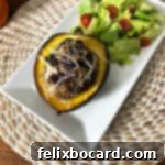 More Than Twenty Dried Cranberry Creations 9 A beautifully plated stuffed acorn squash on a white rectangular platter, accompanied by a fresh green salad.
