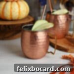 Spiced Apple Moscow Mule 8 Two Apple Cider Moscow Mules in copper mugs, garnished with apple slices.