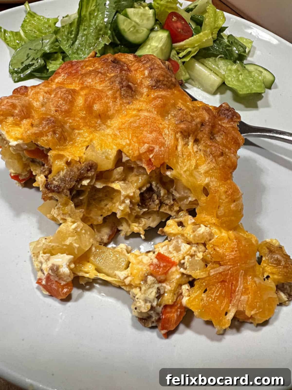 A close-up of a serving of chorizo egg bake, showing the fluffy egg, bits of chorizo, and hash browns, ready to be eaten.