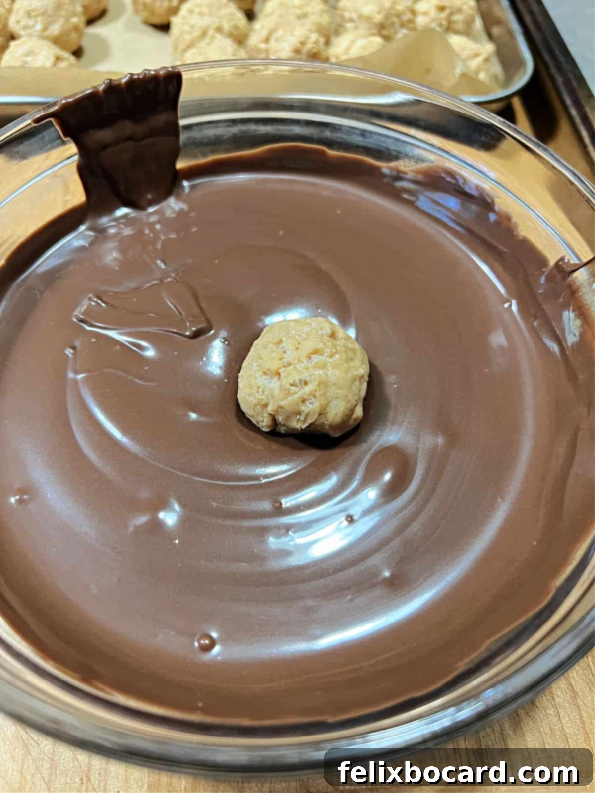 peanut butter ball placed into bowl of melted chocolate.