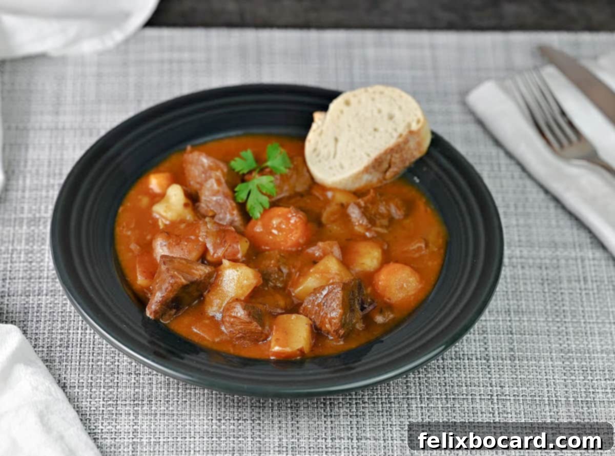 A hearty bowl of Instant Pot Beef Stew, garnished with fresh parsley and served with a slice of crusty bread, presented on a rustic wooden table.