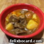 A vibrant red bowl filled with hearty Instant Pot beef stew, a comforting meal for any occasion, ready to be enjoyed.