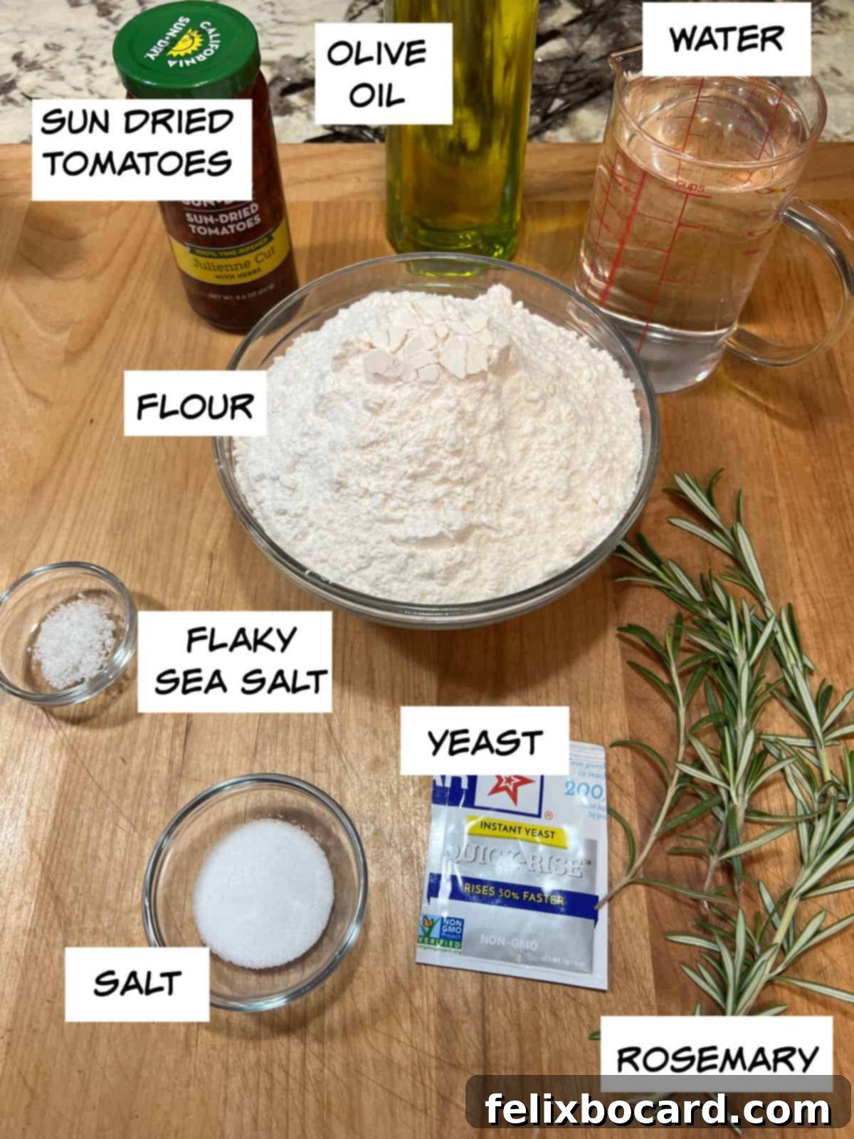 Simple Sun-Dried Tomato & Rosemary Focaccia 3 A collection of ingredients laid out: sun-dried tomatoes, olive oil, warm water, all-purpose flour, active dry yeast, fresh rosemary sprigs, regular salt, and flaky sea salt.