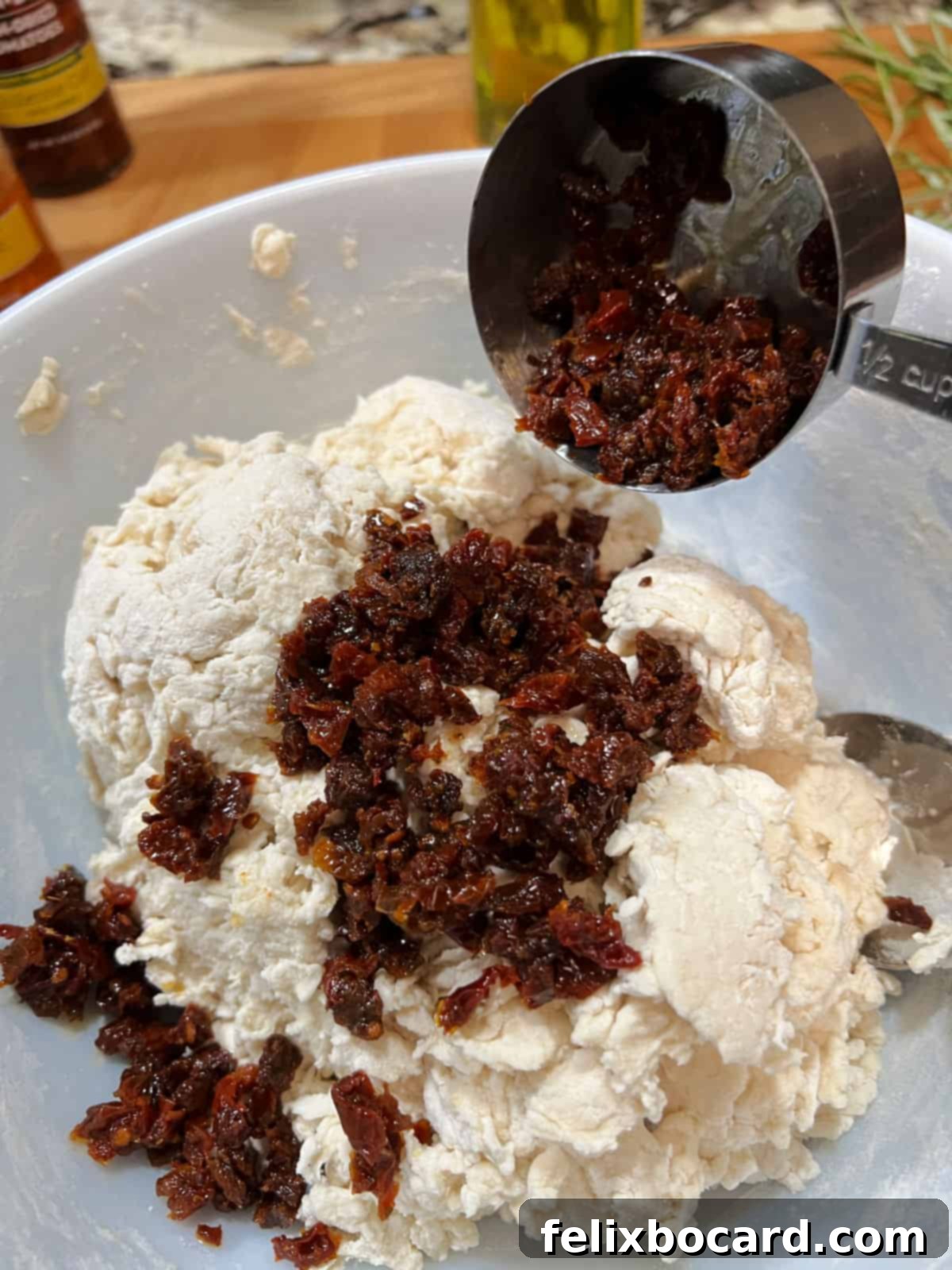 Simple Sun-Dried Tomato & Rosemary Focaccia 4 Focaccia dough being mixed in a bowl with sun-dried tomatoes already added.
