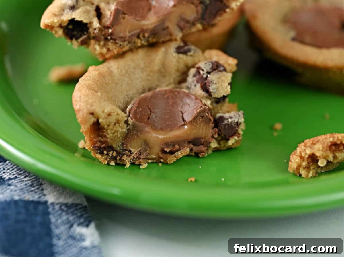 Close up of a freshly baked Rolo stuffed chocolate chip cookie cup, revealing its gooey caramel center.