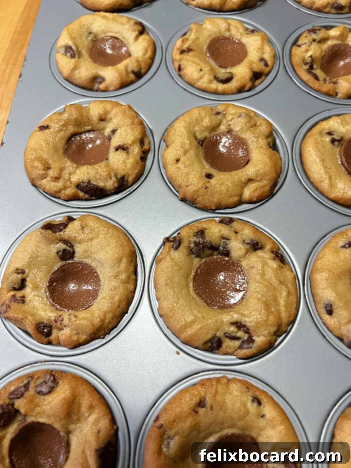 Baked Rolo Cookie Cups cooling in the mini muffin pan after being removed from the oven.