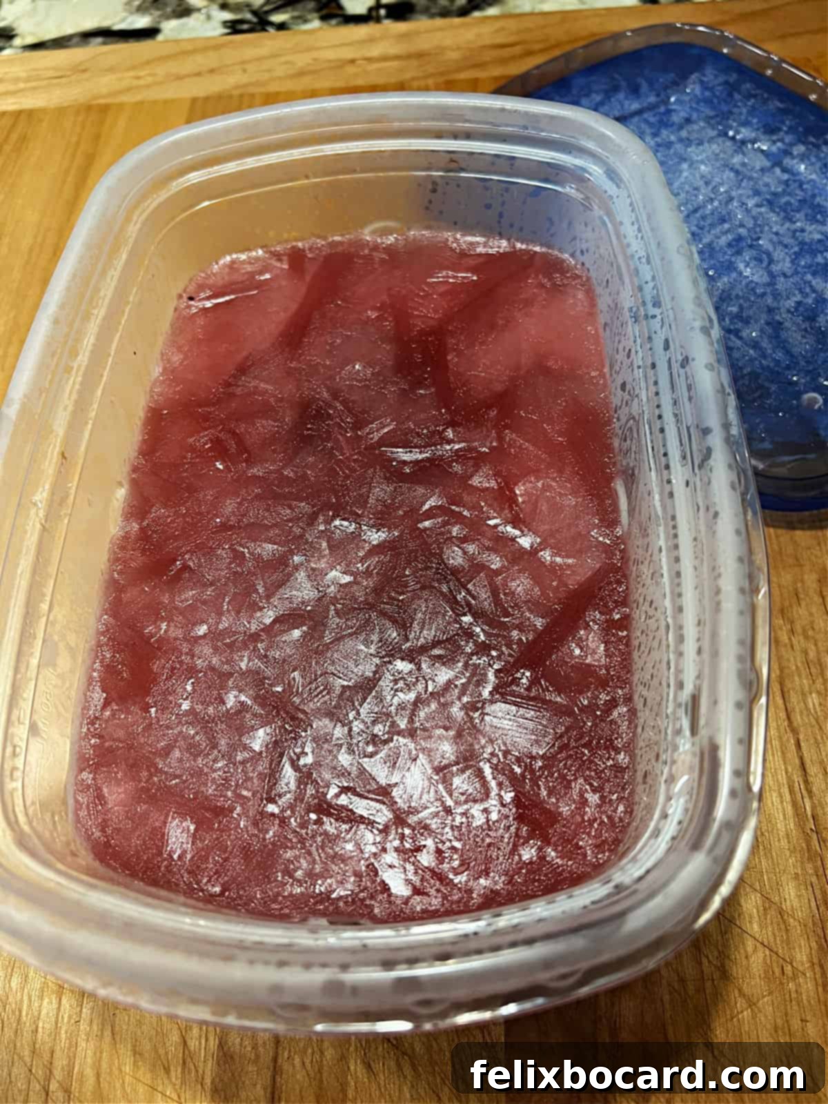 Frozen cranberry rum slush mixture ready to scoop.