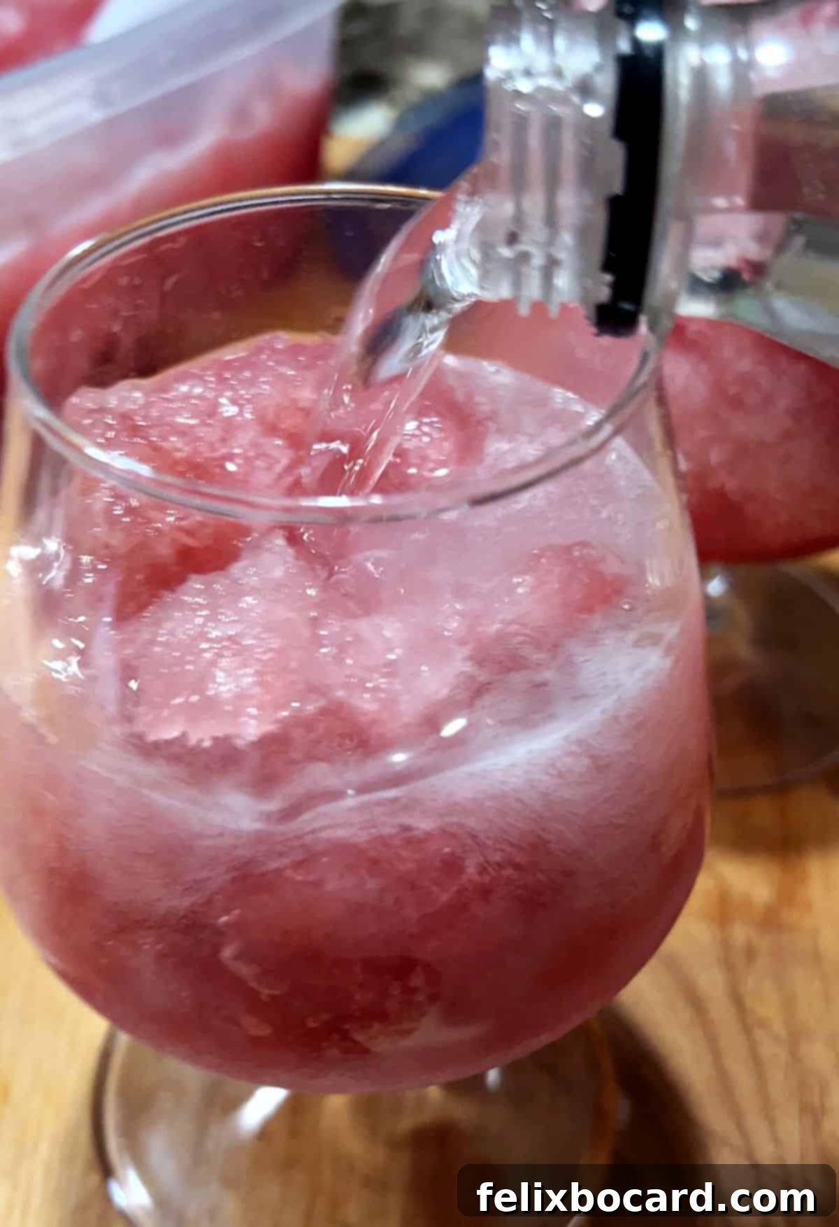 Adding lemon-lime soda to the glass to top the drink.