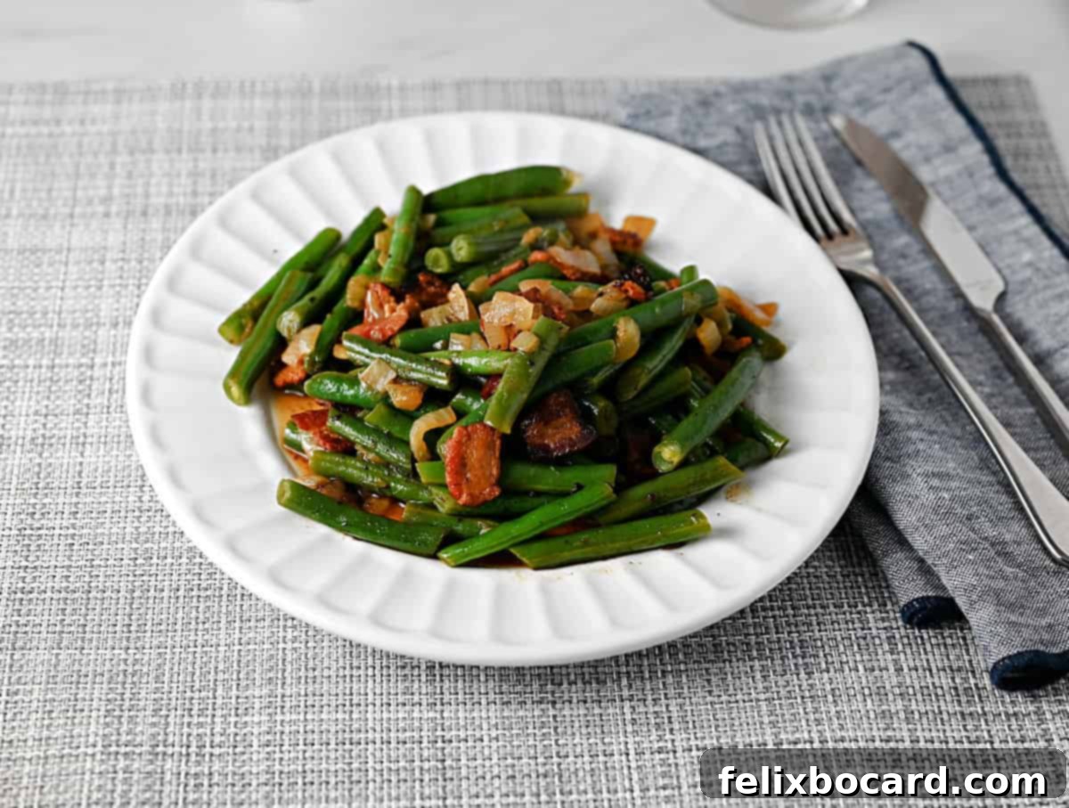 A plate of green beans prepared Texas Roadhouse style, garnished with crispy bacon bits.