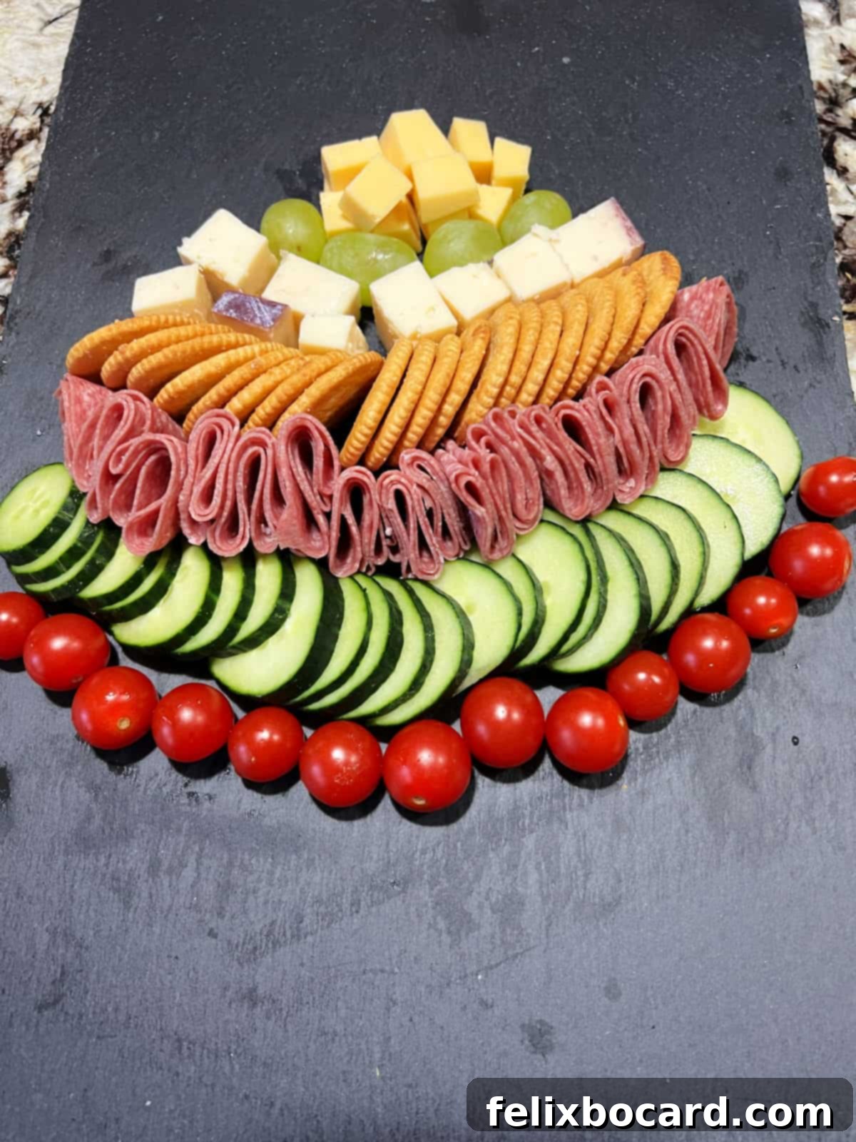 Adding crackers, meat, and other ingredients to make the tree shape.