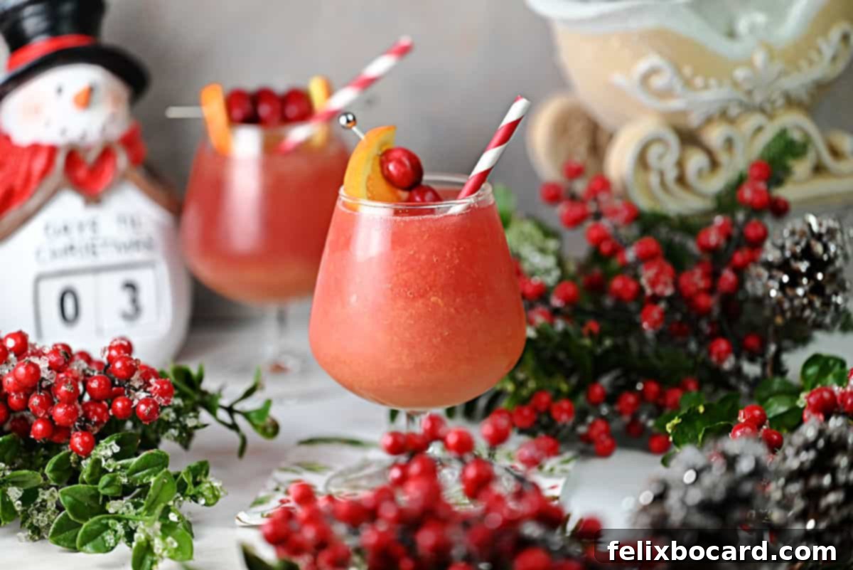 Zesty Cranberry Orange Vodka Chill 2 Two glasses of cranberry orange vodka slush surrounded by festive holiday decor.