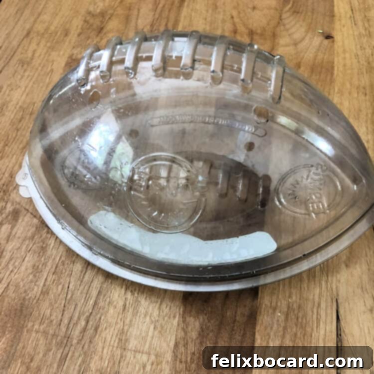 Empty plastic football-shaped mold, a convenient tool for shaping cheese balls.