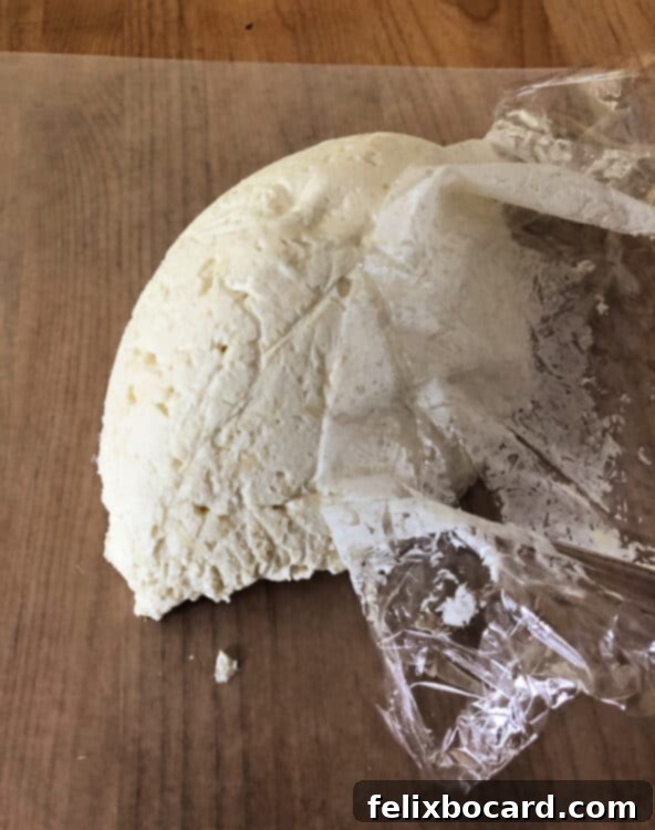 Chopped pecans spread on wax paper, ready for coating the cheese ball.