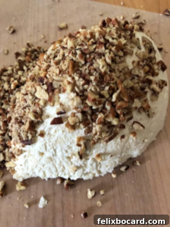 Football shaped cheese ball coated in nuts, ready for laces.