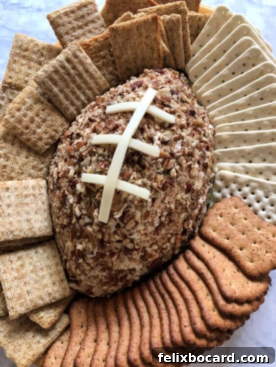 Football Cheese Ball with white cheese laces on a serving platter.