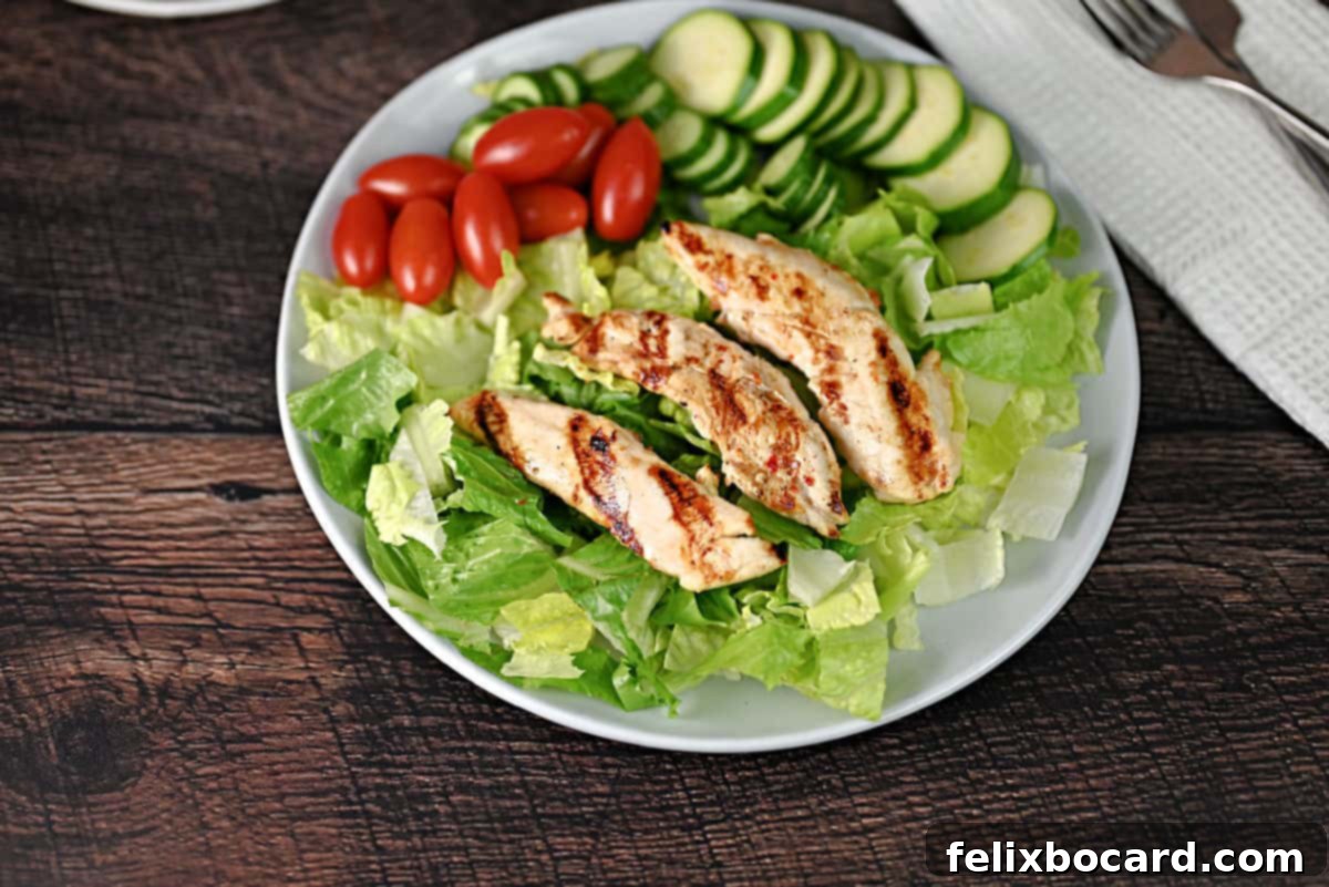 Cooked chicken tenders on a bed of salad greens, ready for a healthy meal.