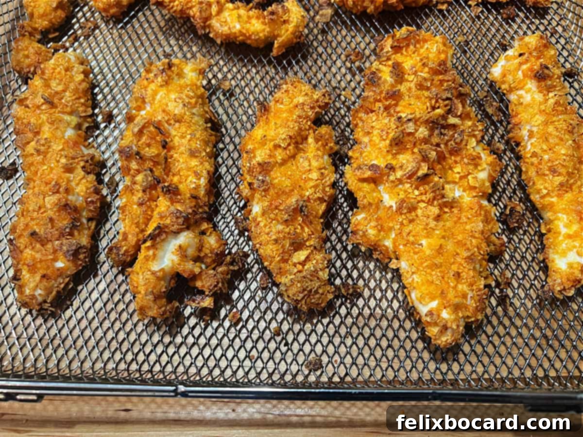 Cooked Doritos chicken tenders in the air fryer basket, crispy and golden.