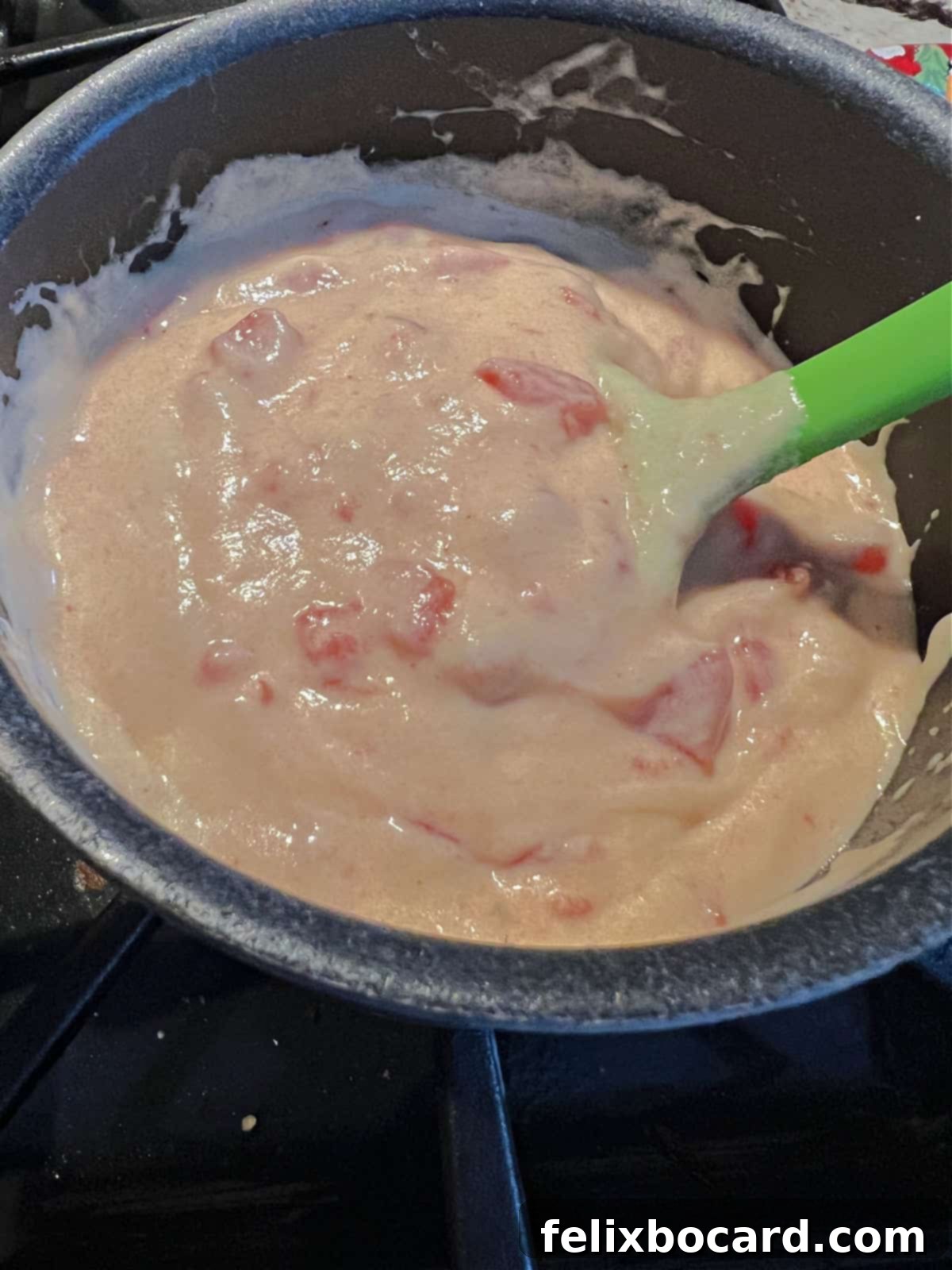 A saucepan filled with a creamy, rich, and perfectly melted easy queso dip, garnished with a sprinkle of fresh cilantro, ready to be served.