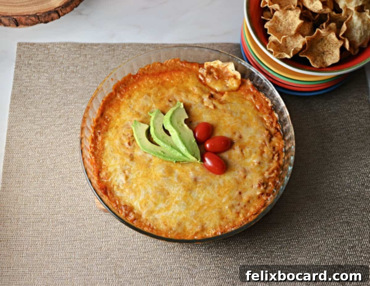 Hot taco dip, perfectly baked and ready to serve, with a scattering of fresh cilantro or green onions.
