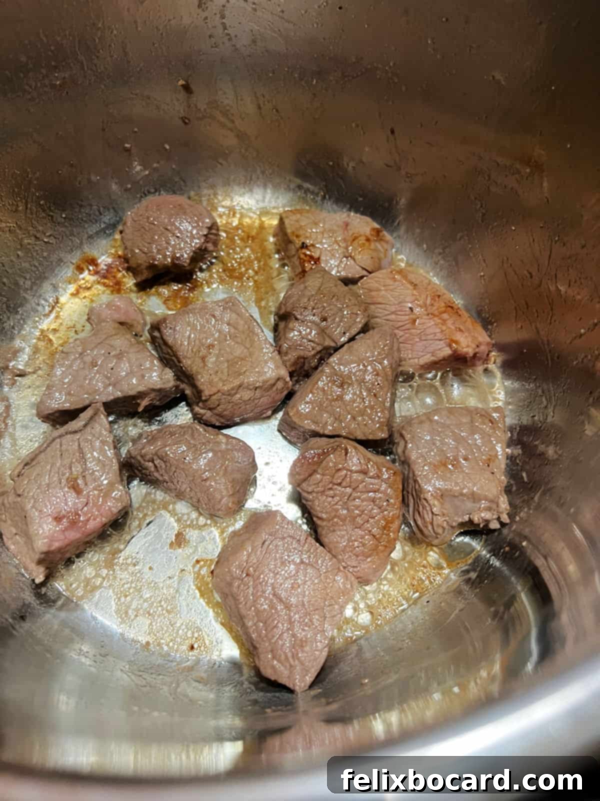 Close-up of beef cubes browning in the Instant Pot, showing a delicious crust forming.