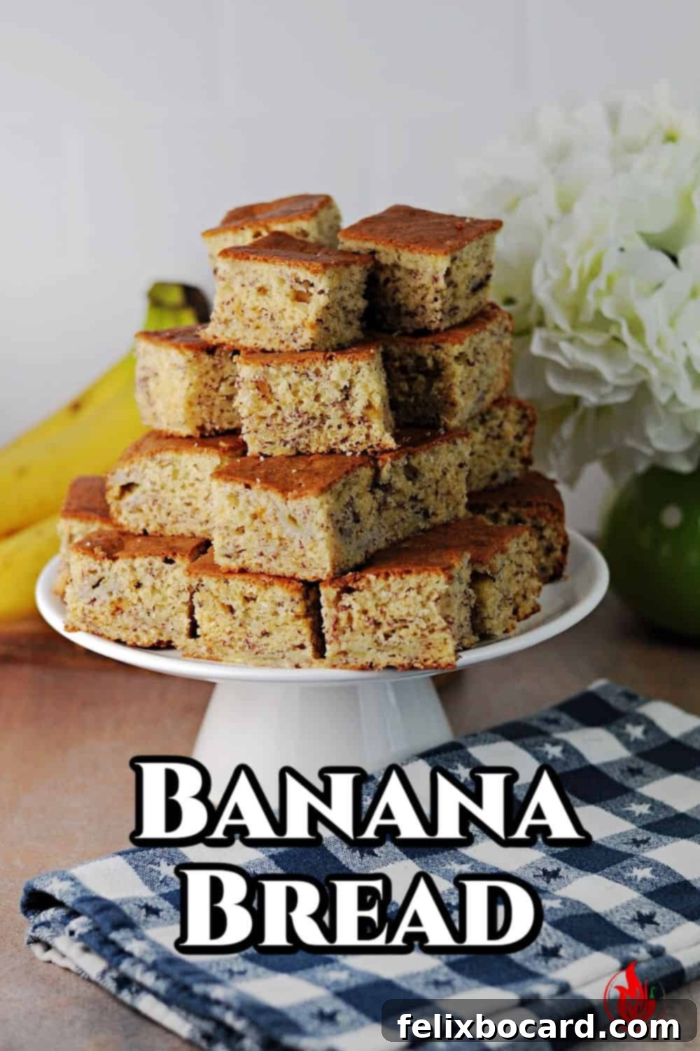 Pin for banana bread showing stack of squares on a small cake server.