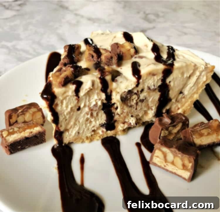 Decadent No-Bake Snickers Treat 5 A perfectly sliced piece of No Bake Snickers Pie on a white plate, ready to be enjoyed.