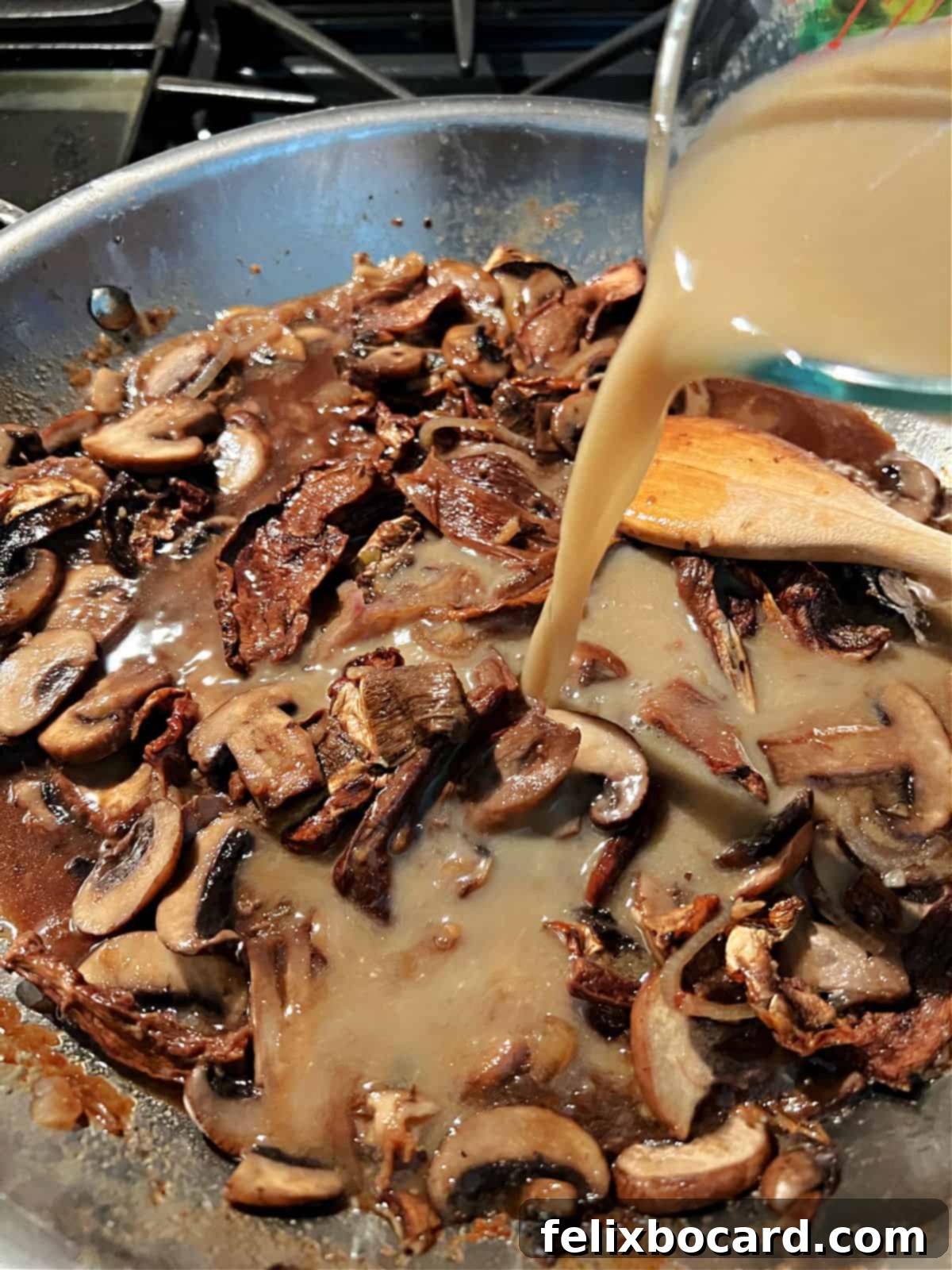 Adding the prepared sauce mixture to the simmering mushrooms and Marsala in the skillet.