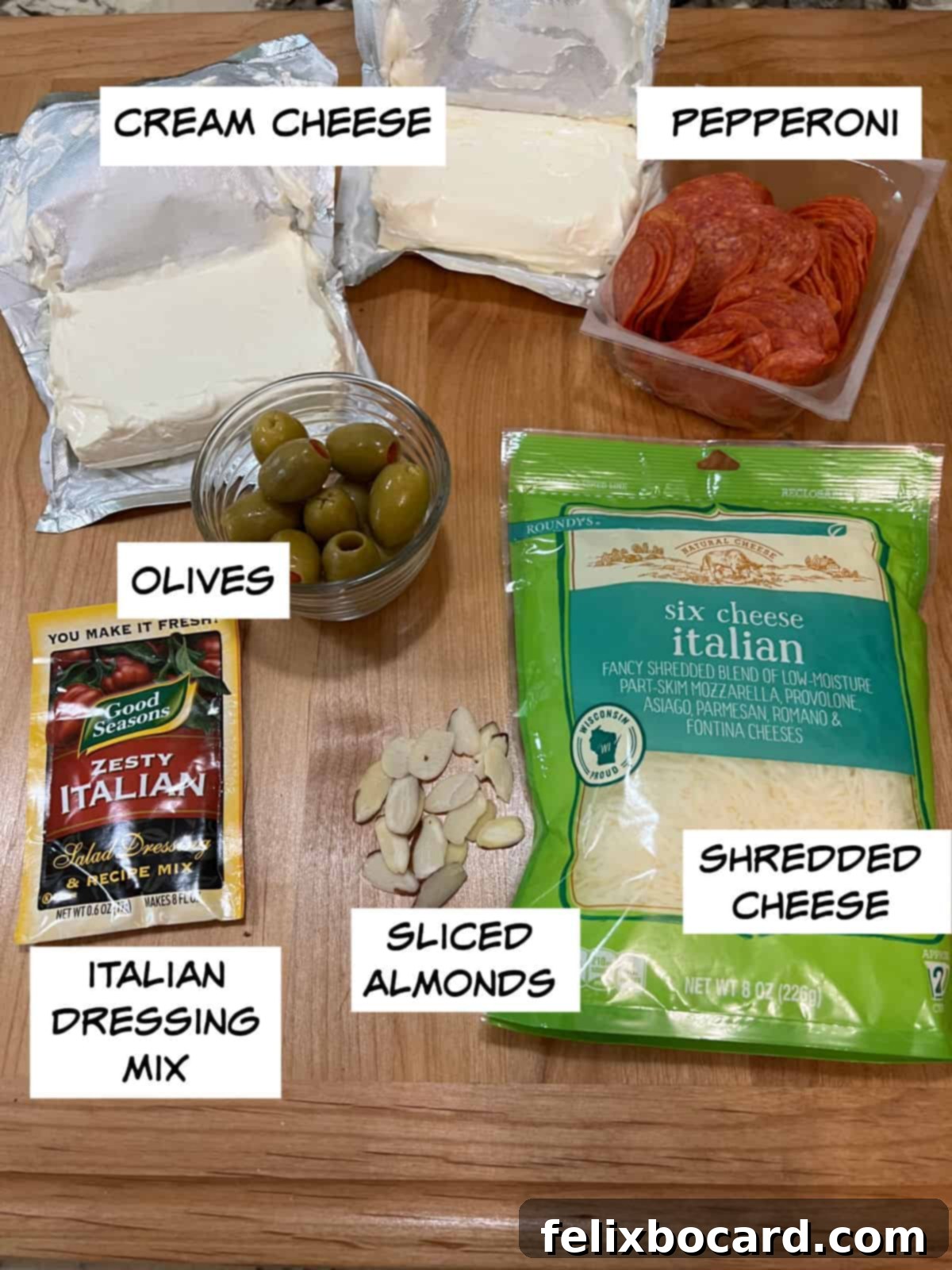 Spooky Pepperoni Skull Cheeseball 2 Ingredients: cream cheese, shredded cheese, pepperoni, Italian dressing mix, olives, and sliced almonds.