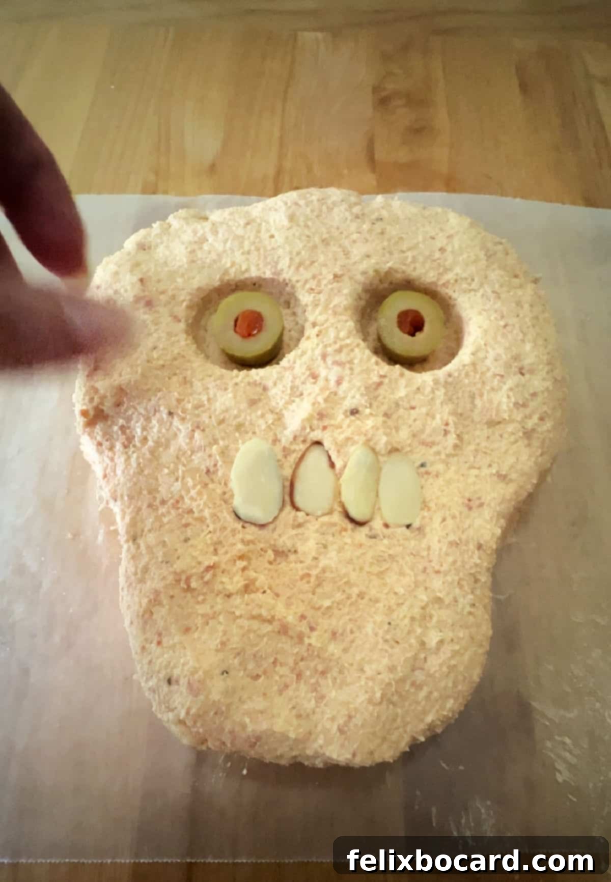 Spooky Pepperoni Skull Cheeseball 8 sliced almonds forming a mouth.