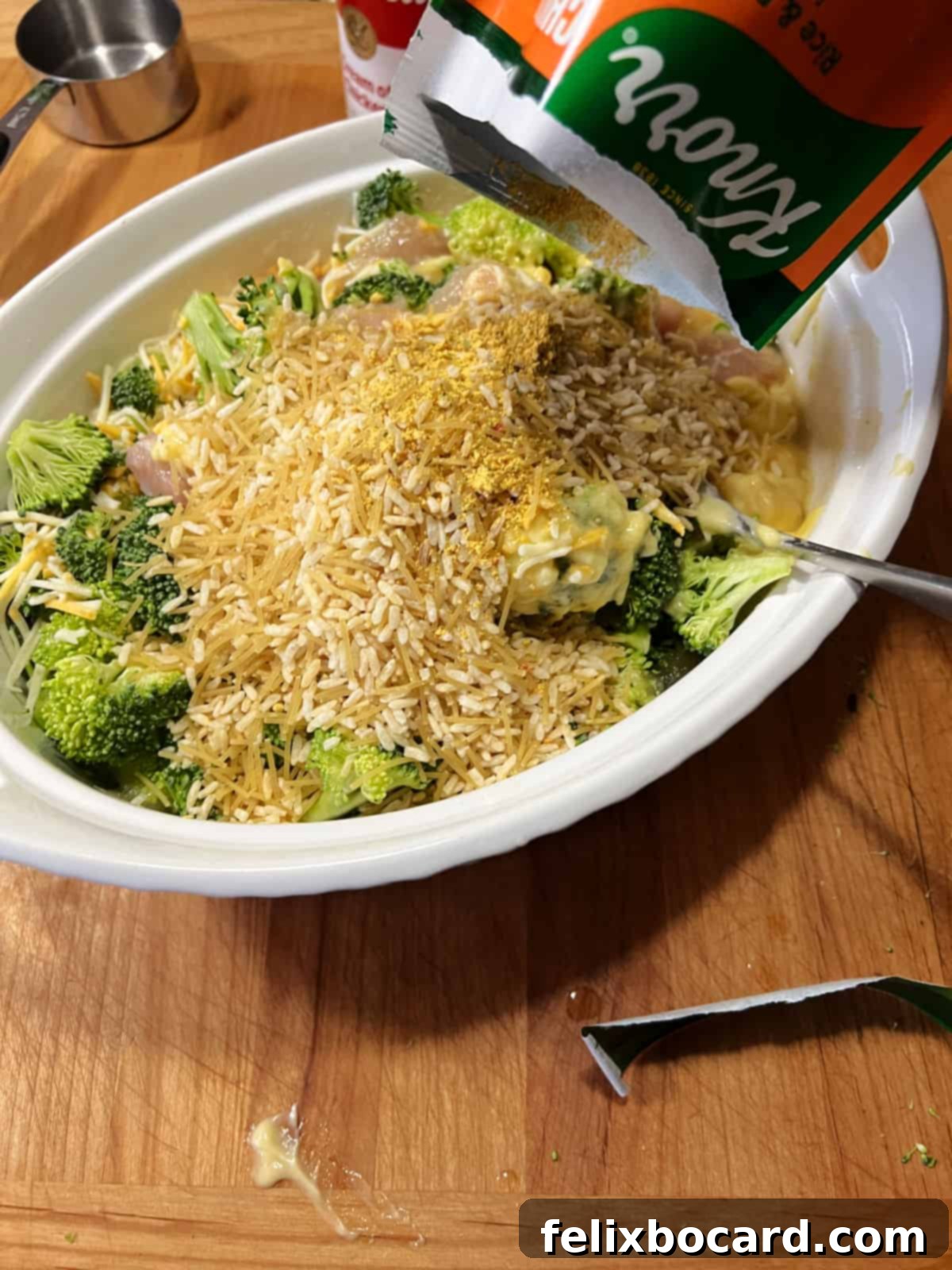 Adding Knorr rice sides packet to the casserole dish.