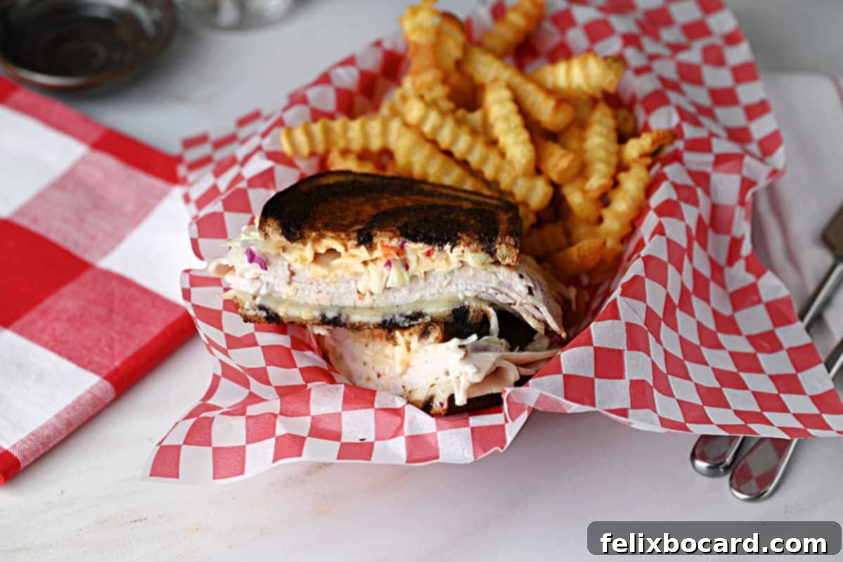 Golden Grilled Turkey Reuben 2 Rachel, grilled turkey Reuben sandwich, served with fries.