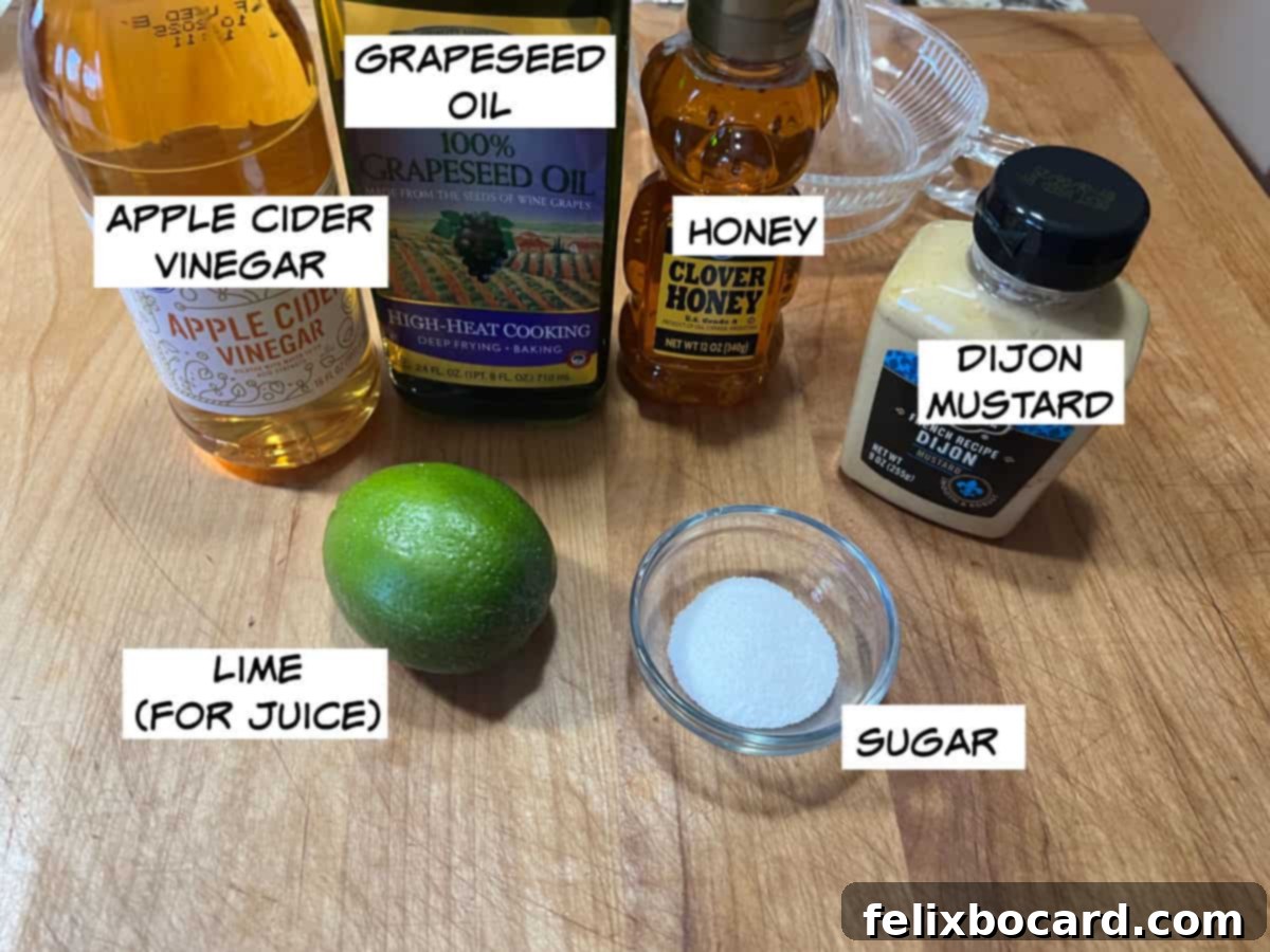 Close-up of fresh ingredients laid out for honey lime dressing preparation: apple cider vinegar, grapeseed oil, golden honey, Dijon mustard, granulated sugar, and bright green limes.