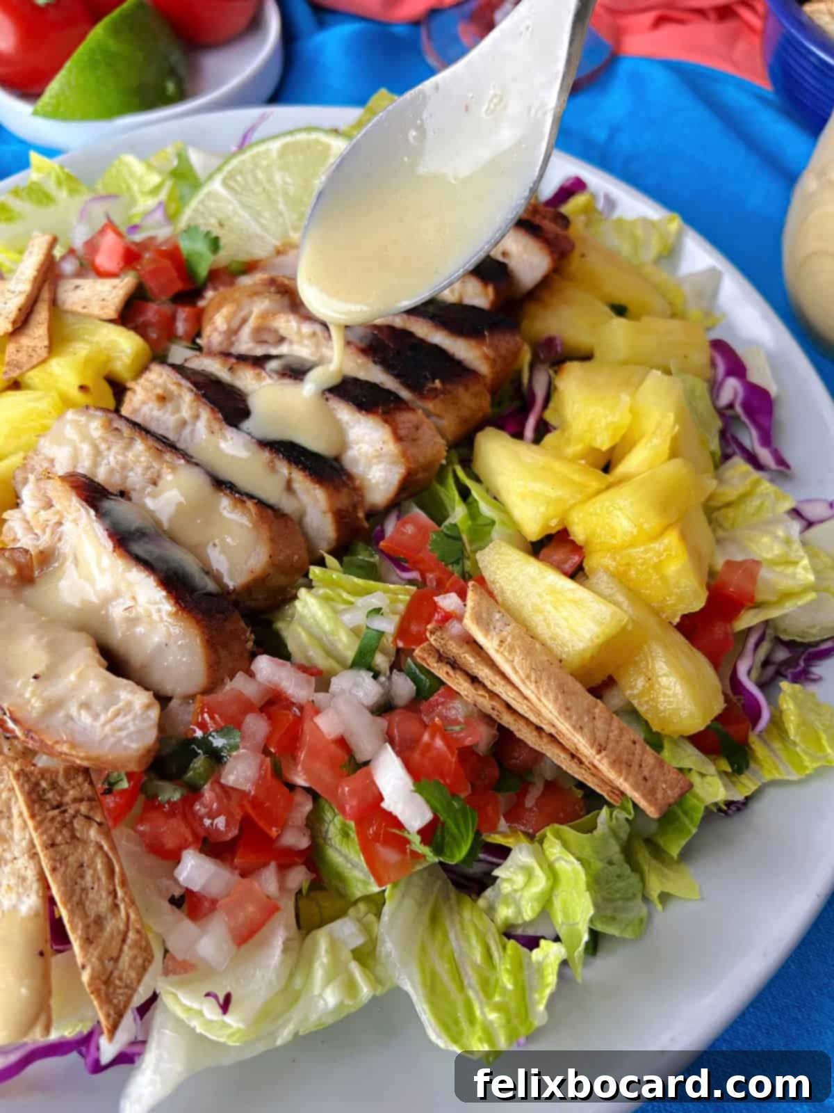 Drizzling homemade honey lime dressing generously over a vibrant grilled Caribbean chicken salad, featuring mixed greens, corn, black beans, and grilled chicken.